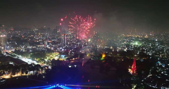 Beautiful aerial view of festive fireworks showing Ho Chi Minh city in Vietnam during Lunar New Year's Eve 2025 with fireworks shooting up and colorful lights on houses. Night celebration