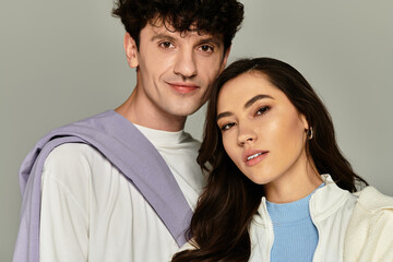 Stylish young couple showcasing trendy fashion in a modern studio setting