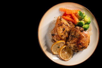 Baked Chicken Thighs with Lemon on black background. Top view