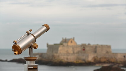 Vintage aluminum and bronze coin-operated public telescope overlooking the Fort National under...