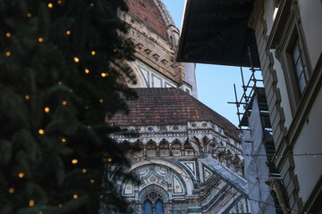 Architectural Scene in Florence, Italy. Detail of one of the absides and the dome of the cathedral. In the foreground, restoration works of classic buildings and Christmas decoration can be seen