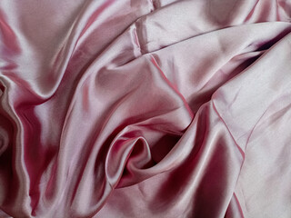 Pink silk fabric for background.The wrinkled light pink fabric lies in folds and drapery. Textile...