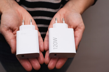 Powerful USB chargers for fast charging for a smartphone in the hands of a woman. We compare the...