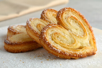 Fototapeta premium Dessert Pastries & Pies, Flaky, golden-brown pastries shaped like hearts, dusted with powdered sugar, perfect for desserts or snacks.