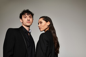 Stylish young couple embraces modern fashion in an urban setting with confident poses