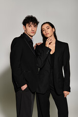Stylish young couple showcases modern fashion in trendy black outfits