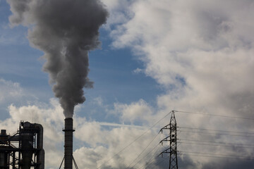 Chimney with smoke from a wood processing industry and an electric power pole. Electricity with...