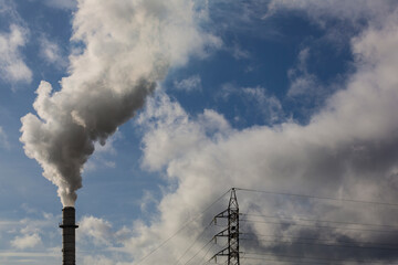 Chimney with smoke from a wood processing industry and an electric power pole. Electricity with...