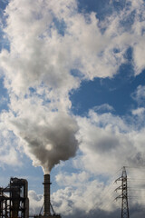 Chimney with smoke from a wood processing industry and an electric power pole. Electricity with...
