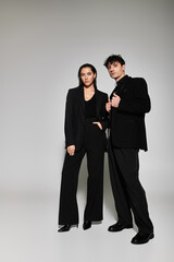 Stylish young couple showcasing modern fashion in a minimalist studio