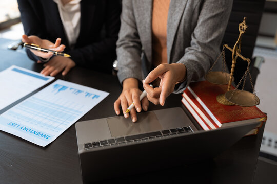 Female legal counsel reviewing paperwork at a desk in an office, working with a tablet on law and justice matters. Professional attorney in a corporate legal.