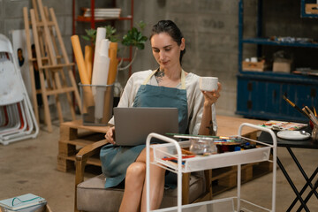 lifestyle female artist painting on canvas in the home studio.