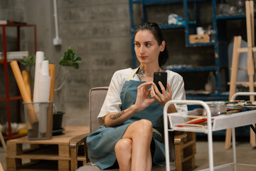 lifestyle female artist painting on canvas in the home studio.