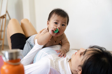 Mother and baby sharing a playful moment with toys on the floor