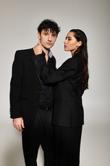 Young stylish couple showcases trendy fashion in a modern studio setting