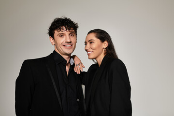 Young and stylish couple showcasing modern fashion in a trendy studio backdrop