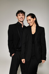 Stylish young duo showcasing modern fashion in a minimalist studio setting