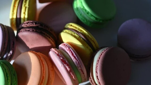 colorful macaroons rotate in harsh light.