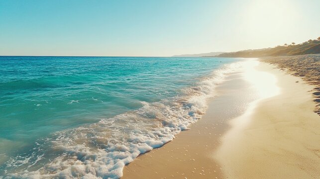 Peaceful beach with white sand and clear turquoise waves rolling into the distance