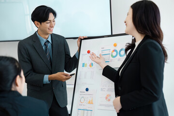 Collaborative business professionals discussing data insights during a presentation in a modern office.
