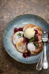 pancakes with cream and berries on the marble table with spoon,