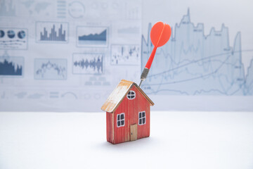 Dart arrow, house model with a financial graphs.
