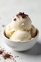 Dark chocolate shavings sprinkled on top of a scoop of creamy white stracciatella ice cream, creamy, indulgent, white