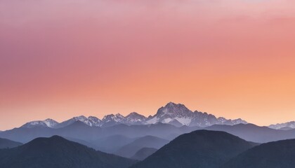 Sunrise over a serene mountain range with a soft orange and pink sky