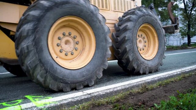 Close-up of Road Grader Clearing Grass from Road Edge at Construction Site for Asphalt Removal in Preparation of New Asphalt Layer