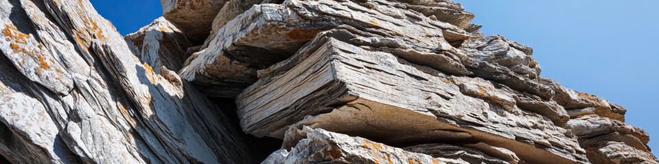 Layered Sedimentary Rock Formation with Blue Sky Background