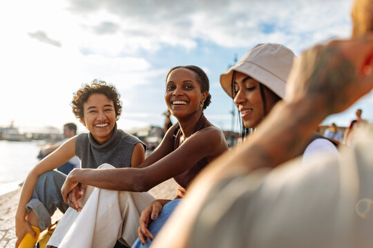 Group of young women smiling and relaxing by the river