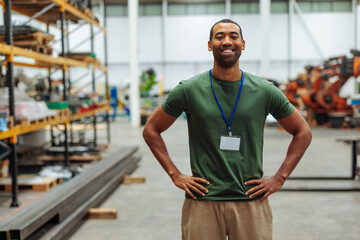 Smiling supervisor posing with hands on hips in warehouse