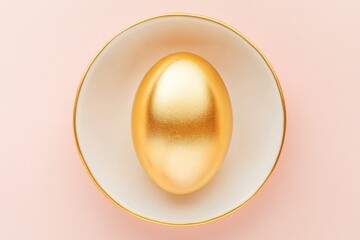 Elegant Golden Easter Egg Resting on a White Ceramic Plate Against a Soft Pink Background