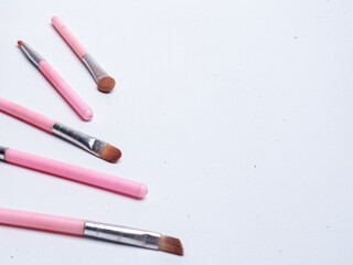 detail, Set of pink make up brushes and beauty cosmetic products for makeup artist over pastel background. Flat lay, top view, copy space, Professional makeup tools. Makeup products on pink