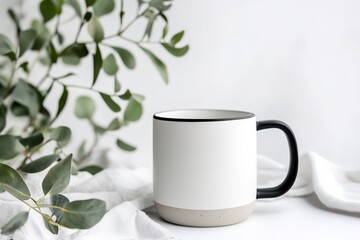 Blank white mug with eucalyptus leaves on white linen.