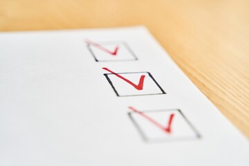 Checklist marked red with a red pen. Close up shot of filled check boxes with red pen