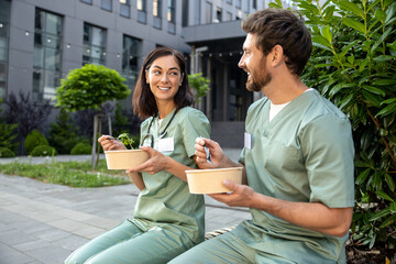 Two doctors having lunch together in the clinic yard