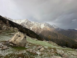 Snowy mountains landscape in the indian Himalayas. View of Dhauladhar Range partly covered with clouds and snow. Triund trek, Dharamsala, Himachal pradesh, India.