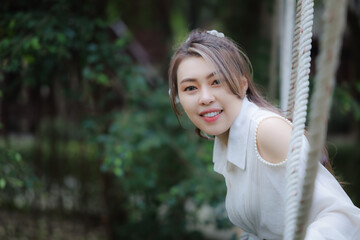 Obraz premium portrait of asian woman wearing white dress in the park, my vacation relax