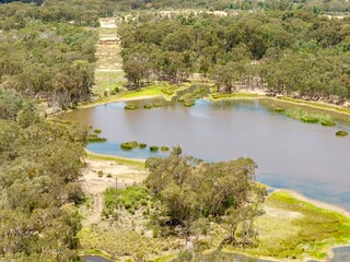 Fototapeta premium Aerial View from a drone of a landscape lake overlooking the trees out near Emmaville, NSW, Australia 
