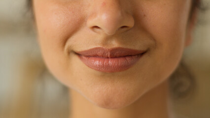 Fototapeta premium Close up female lips sensual toothy smile white healthy teeth cropped view unrecognizable Indian Arabian woman girl lady female indoors smiling dental oral medicine clinic dentist joyful happy glad