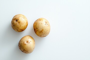 Fototapeta premium Three fresh potatoes on a white background in a simple and clean food photography style