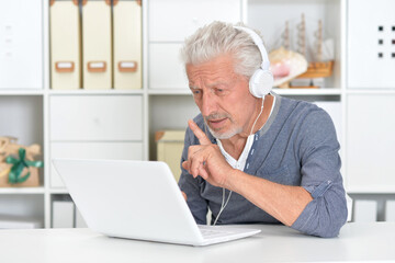 Fototapeta premium Portrait of senior man with laptop at home