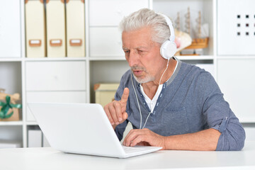 Fototapeta premium Portrait of senior man with laptop at home