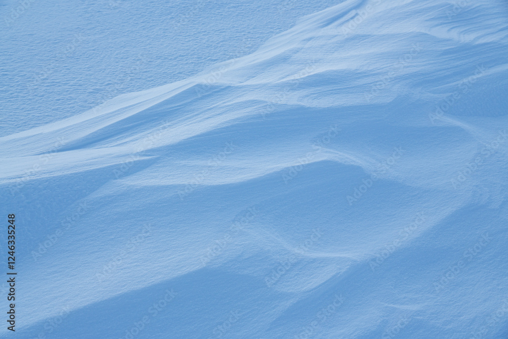 Wall mural snow texture. wind sculpted patterns on snow surface. wind in the tundra and in the mountains on the