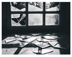 Shattered window, indoor scene, sunlight, broken glass, room damage, stock photo