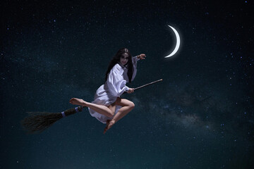Mystical witch, woman in white gown stealing moon, flying on broomstick against dark night starry sky background. Concept of fantasy, magic, mystery, supernatural, fantasy. Book and movie covers ideas