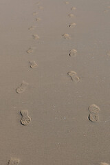 Footprints in the sand on the beach, closeup of photo