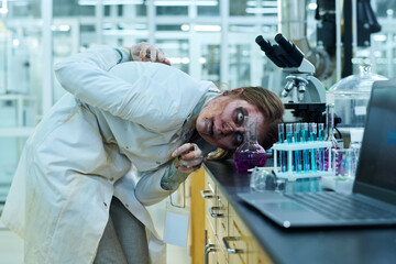 Creepy Zombie Looking At Toxic Liquid In Flask