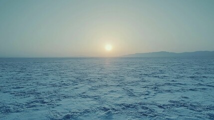 Obraz premium Serene Sunrise Over Snowy Landscape with Gentle Warmth on Horizon